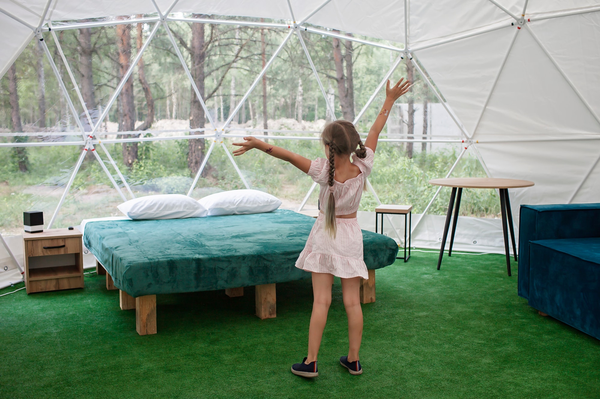 girl-looks-over-transparent-bell-tent-in-forest-glamping-luxury-travel-glamourous-camping.jpg